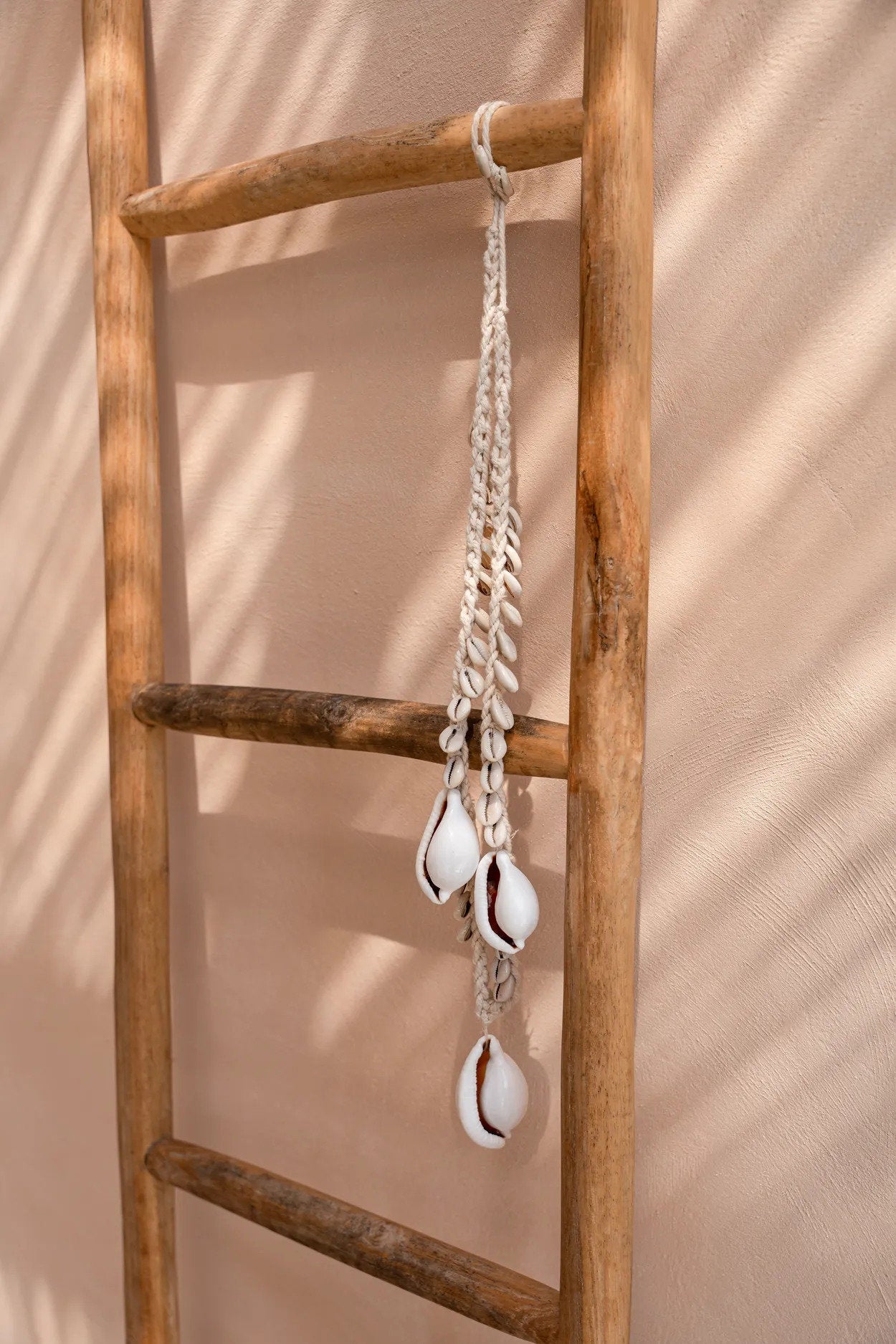 Collier décoratif coquillages cauris blancs en corde tressée suspendue