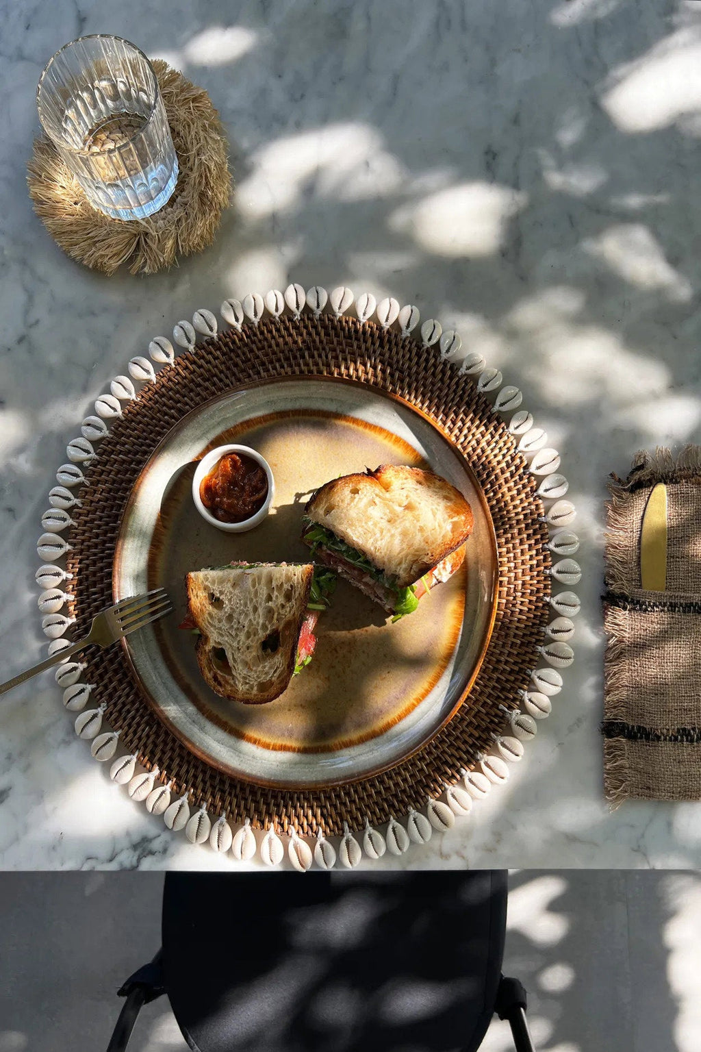Set de table rond en rotin marron avec bordure de coquillages cauris