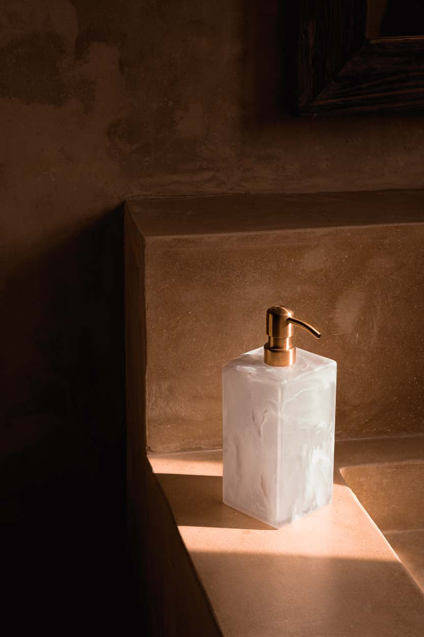Distributeur de savon en résine marbrée rose et blanche avec pompe dorée