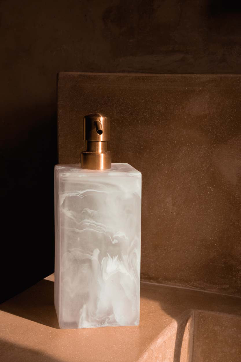 Distributeur de savon en résine marbrée rose et blanche avec pompe dorée