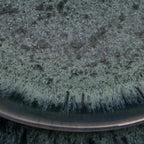 Assiette creuse en grès émaillé vert émeraude moucheté, bord métallique
