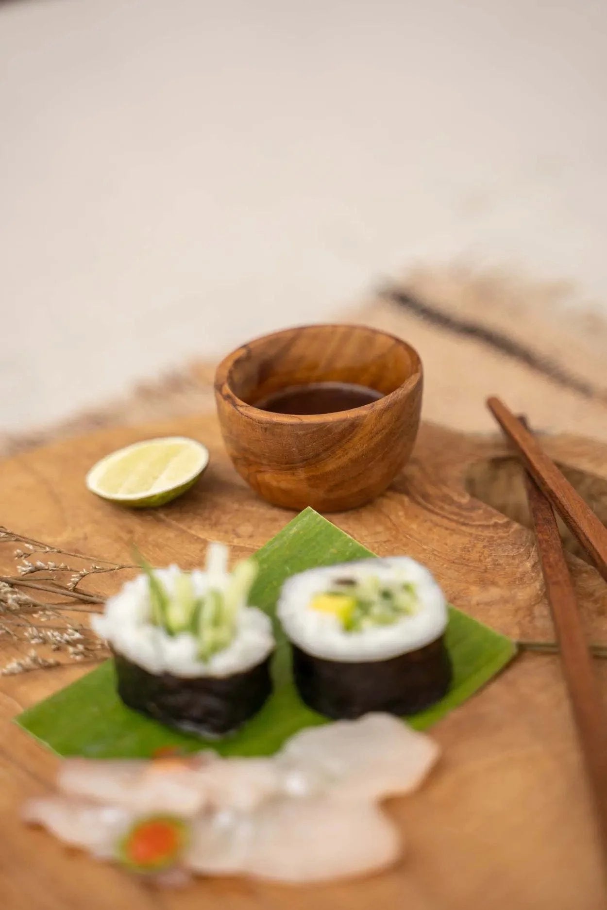 Sushi avec légumes frais, bol en teck pour sel ou épices, sauce soja et citron vert