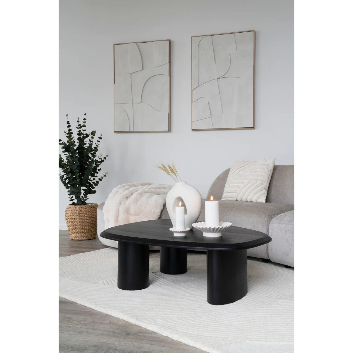 Table basse ovale noire avec pieds cylindriques épais