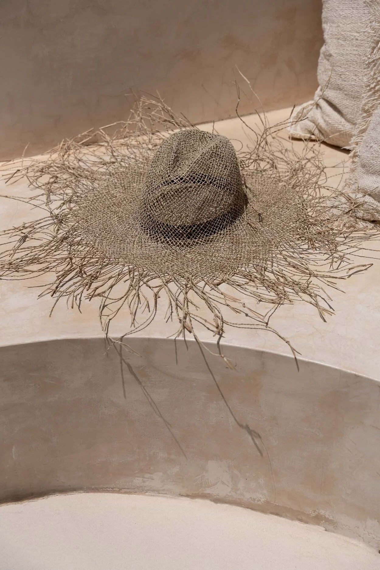 Chapeau de plage naturel en herbe marine texturé, large bord orné de brins délicats