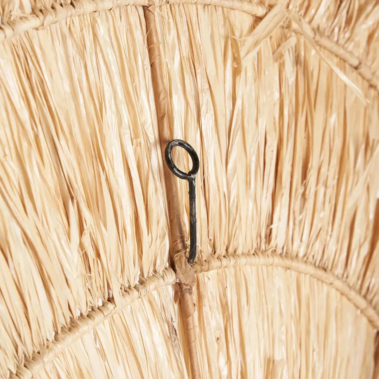 Crochet en métal noir fixé sur surface en sisal beige effet soleil, décoration murale ronde