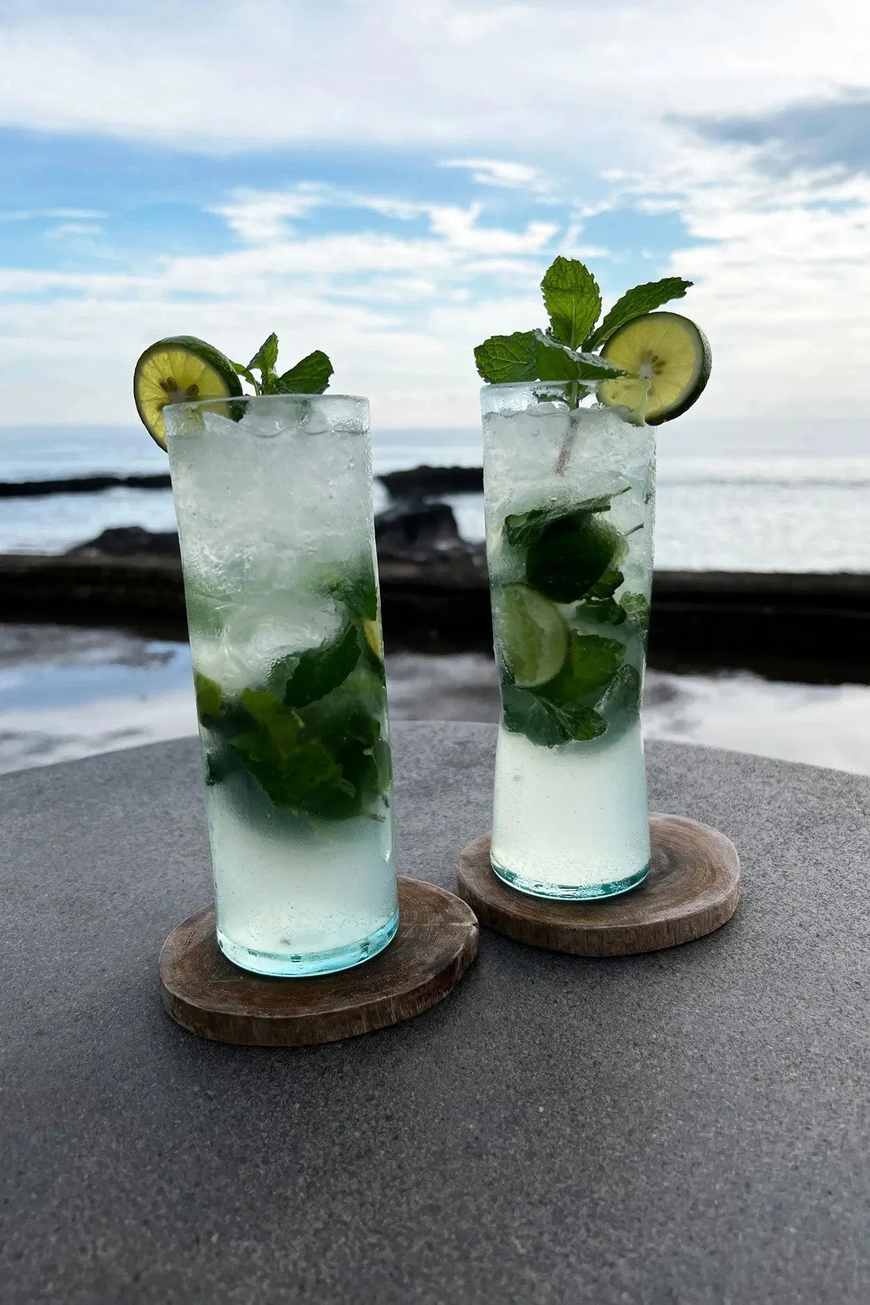 Dessous de verre rond en racine de teck avec mojitos rafraîchissants garnis de lime et menthe