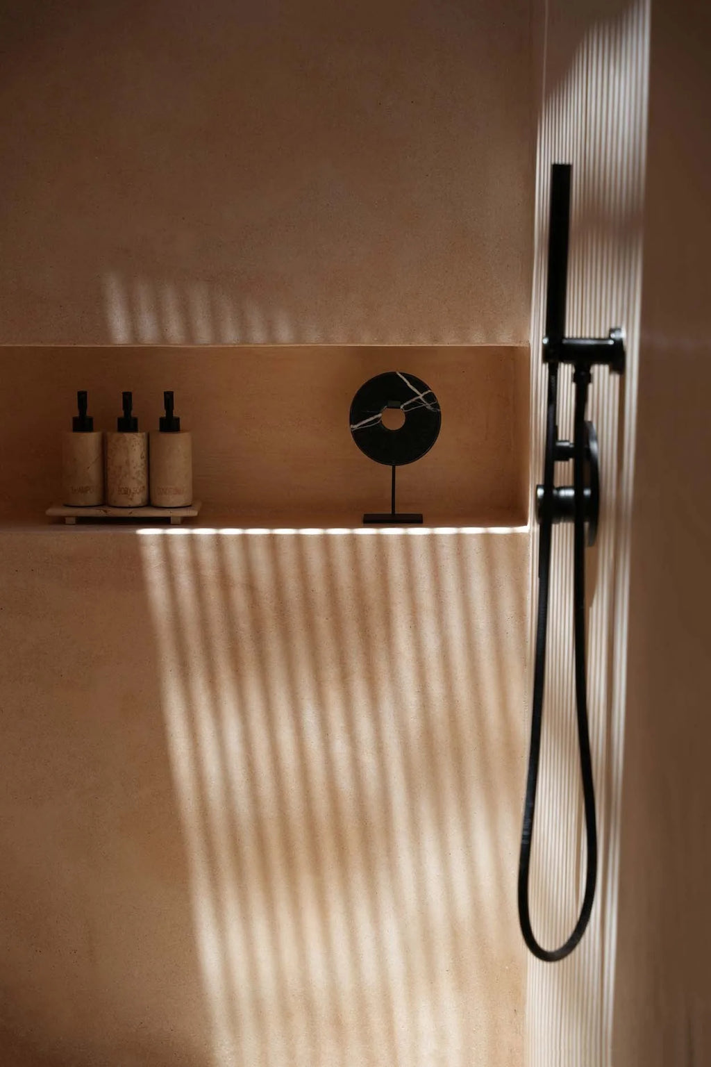 Système de douche noir moderne avec tête de douche à main sur un socle en marbre noir