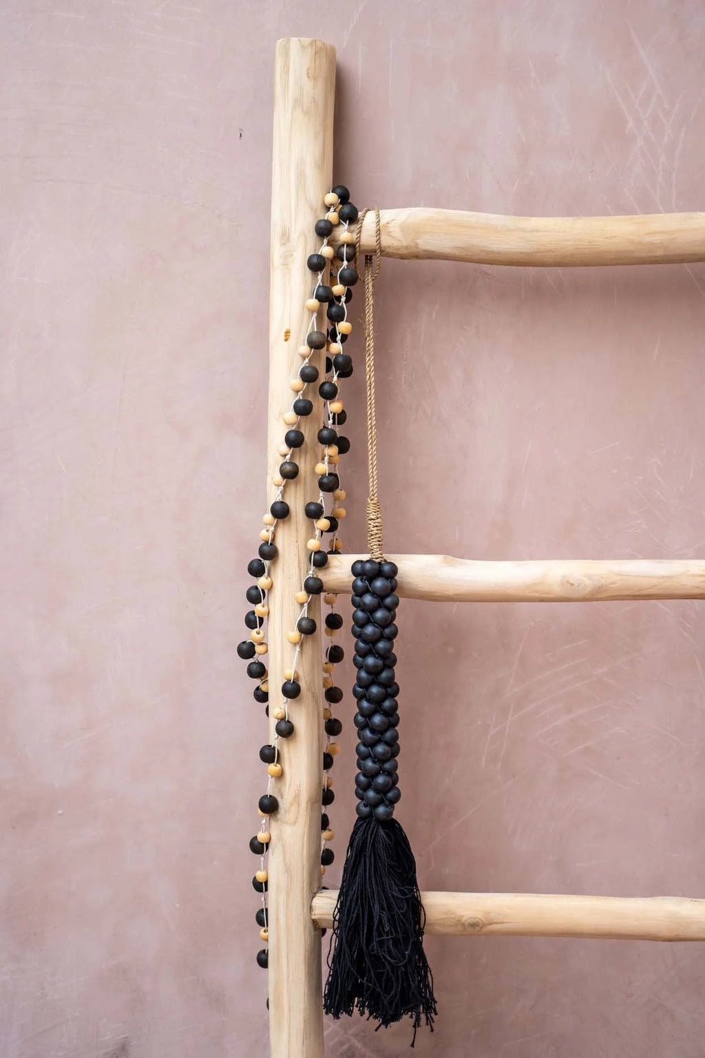 Échelle en bois avec collier de perles noires et gland torsadé
