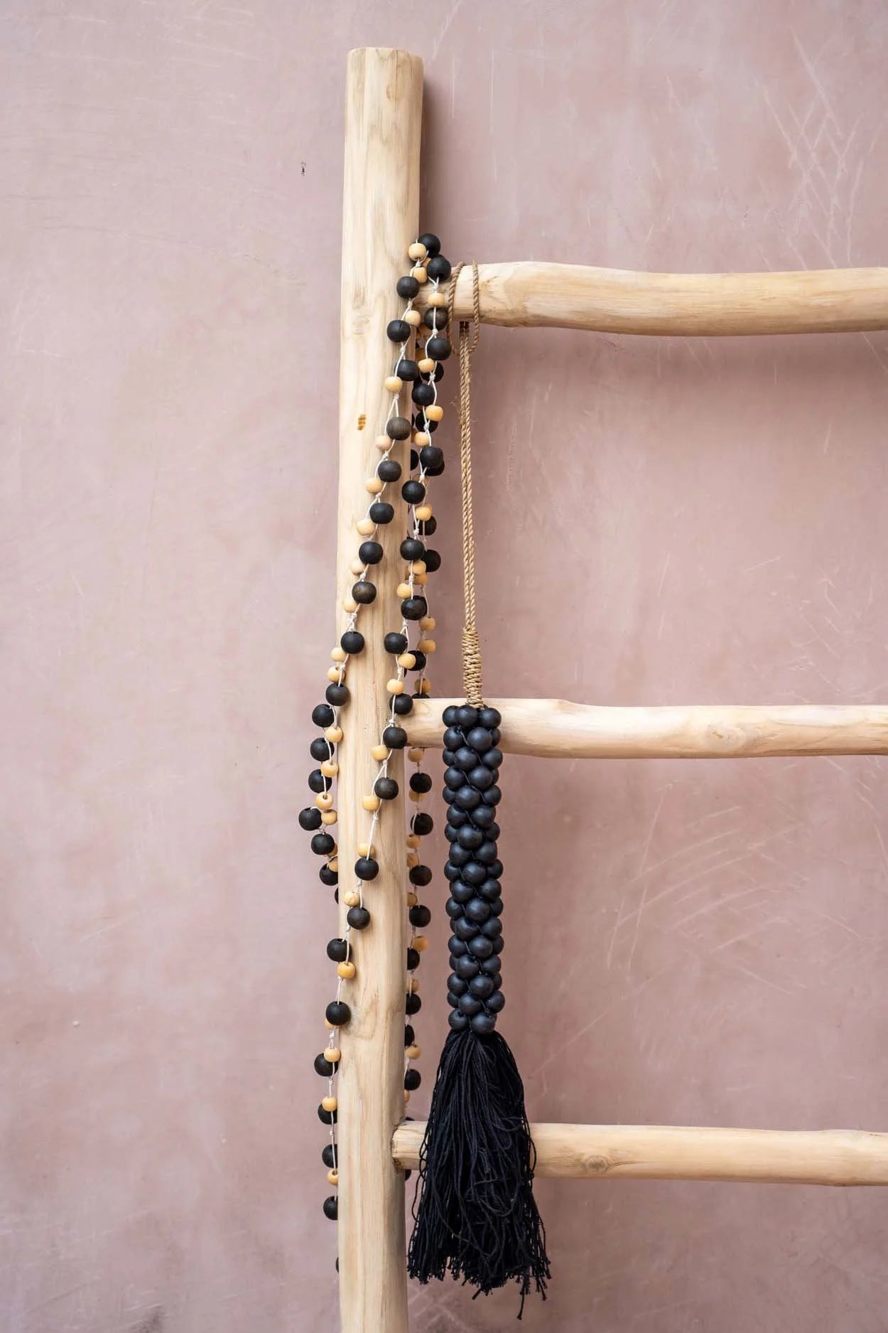 Échelle en bois avec collier de perles noires et gland torsadé