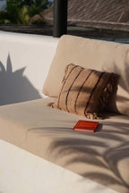 Coussin en coton beige noir 40x40 cm avec livre orange à dos rouge