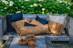 Housse de coussin en coton cannelle noir 35x100 cm sur un banc en bois avec coussins et bougies