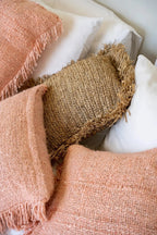 Coussin en coton rose saumon avec textures naturelles et tons neutres