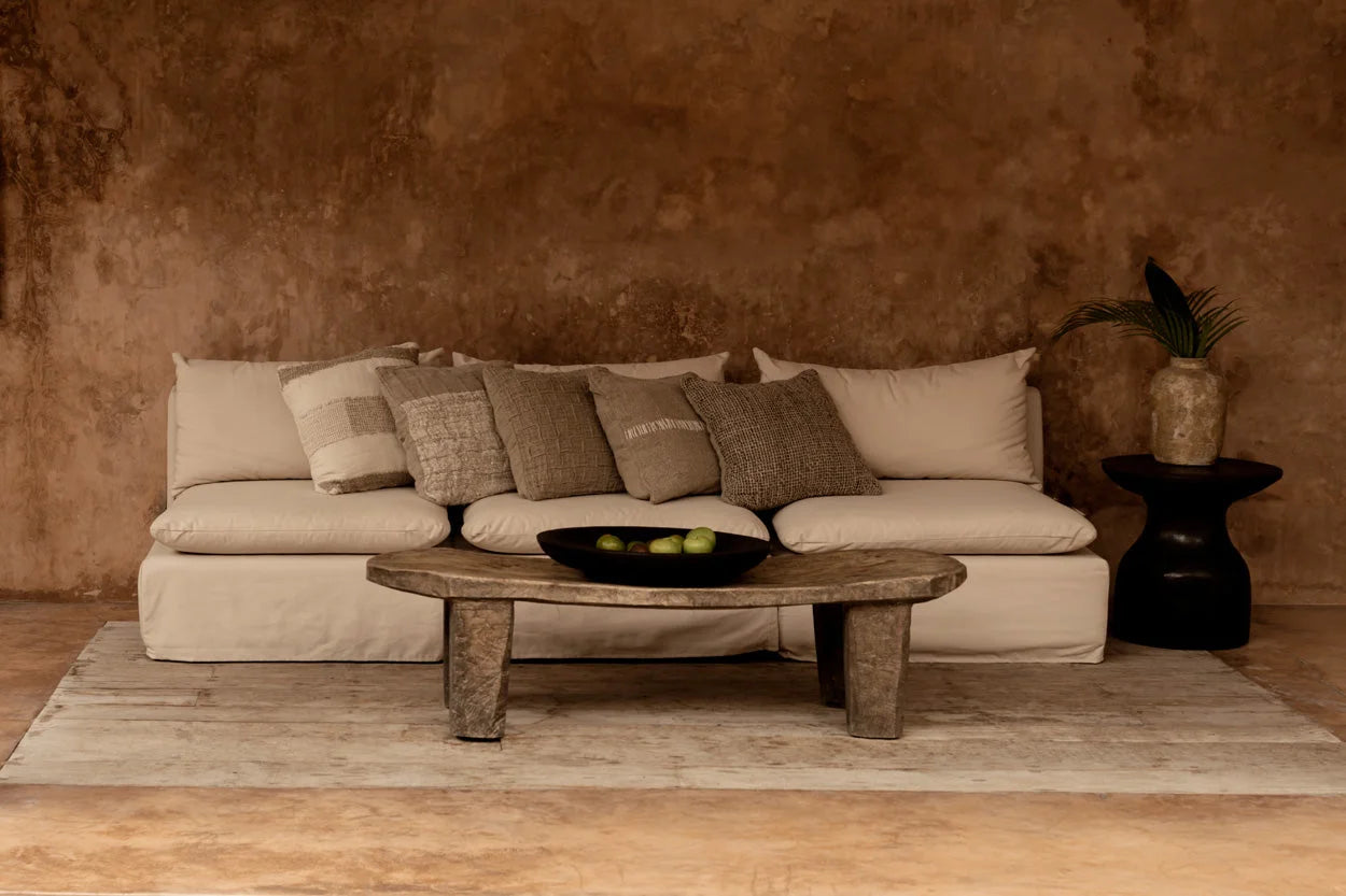 Canapé en lin beige avec coussins à carreaux relief et table basse en bois rustique