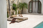 Housse de coussin rectangulaire en raphia naturel avec franges sur un outdoor daybed avec oreiller et chapeau