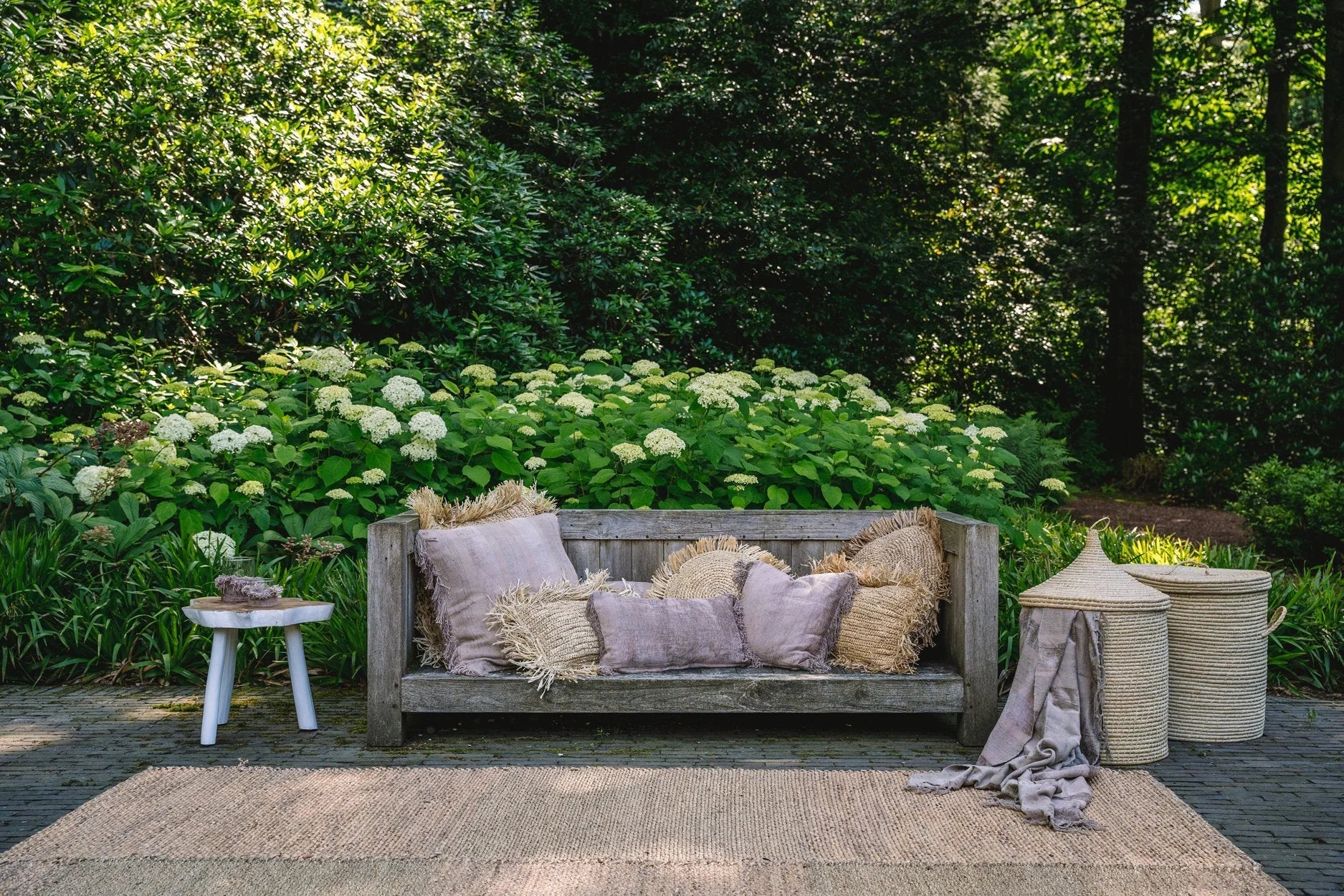 Banquette extérieure en bois rustique avec coussins en velours côtelé beige et franges