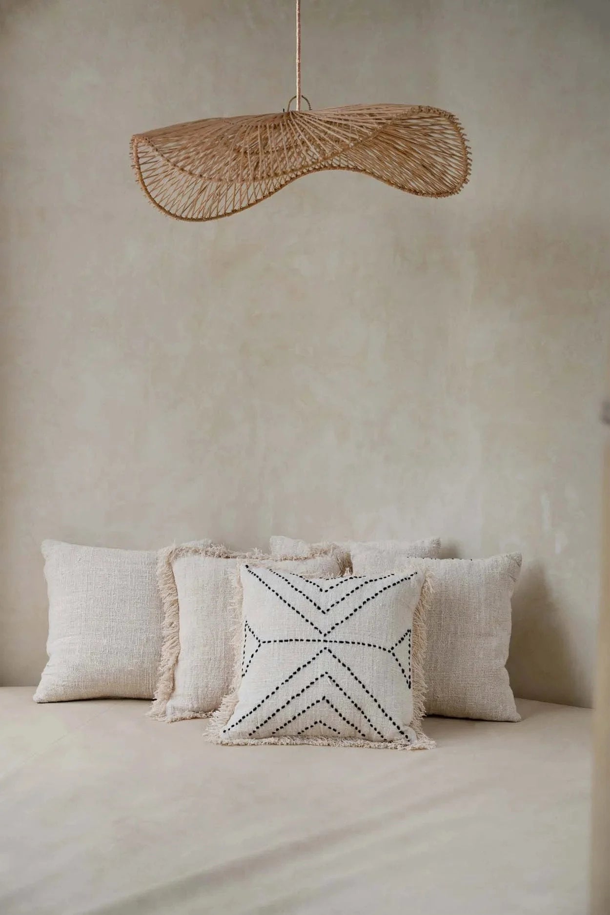 Une suspension en osier tressé de couleur naturelle avec une forme organique en éventail pour un salon design