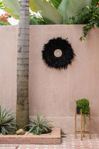 Juju hat rond en plumes noires avec centre tissé et coquillages décoration murale