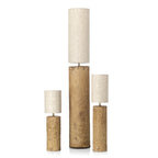 Trois lampes à poser cylindriques en liège texturé ocre avec abat-jours en lin blanc cassé de hauteurs variées