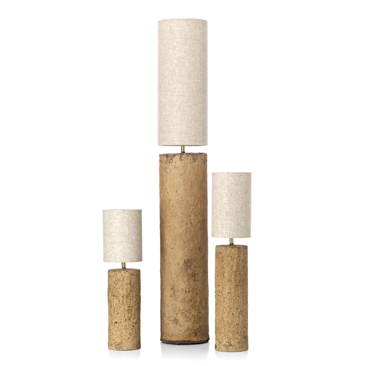 Trois lampes à poser cylindriques en liège texturé ocre avec abat-jours en lin blanc cassé de hauteurs variées
