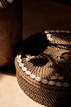 Panier rond en rotin brun avec lid orné de coquillages cauris