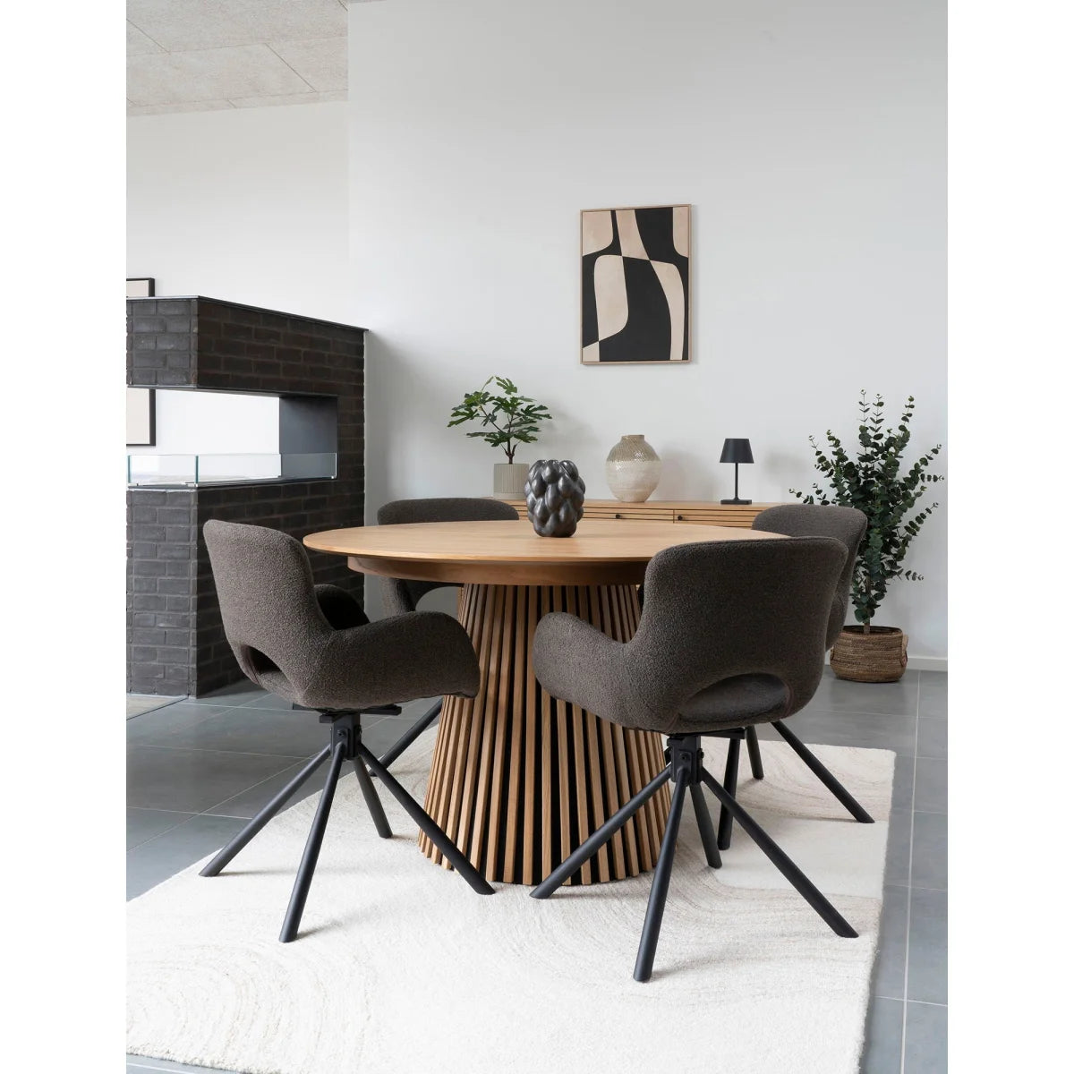 Table ronde en bois avec base ajourée et chaises capitonnées gris foncé