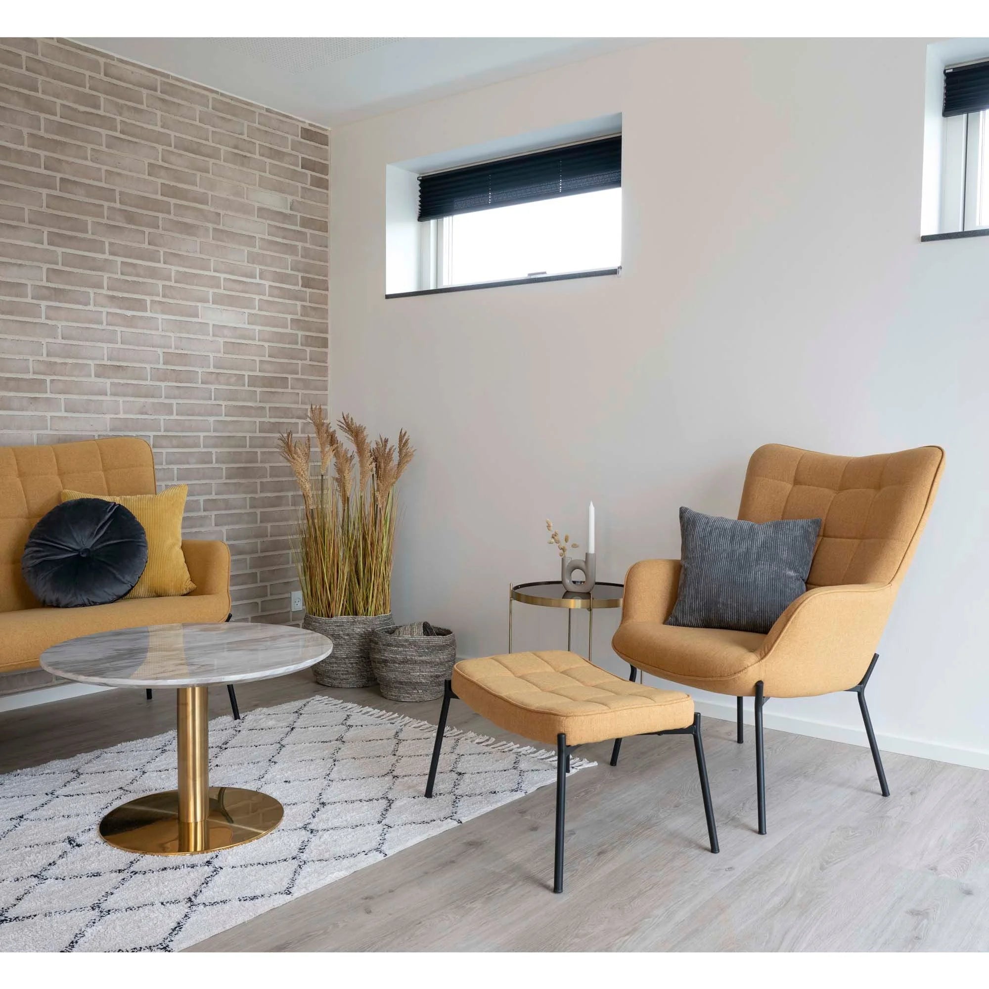 Fauteuil beige rembourré à pieds noirs avec pouf assorti