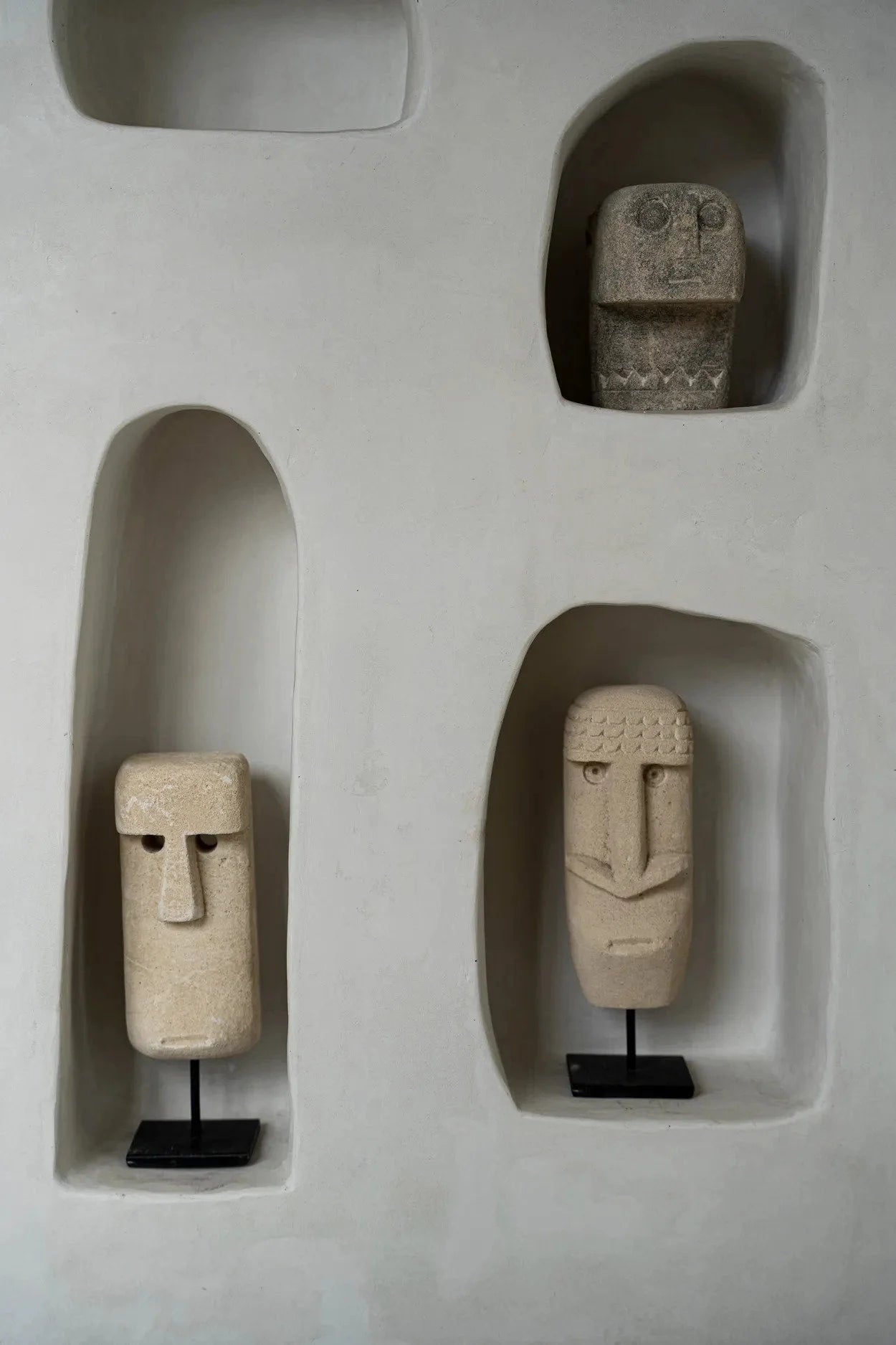Quatre têtes décoratives sculptées à la main en grès beige dans des niches murales