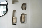 Mur avec niches intégrées affichant des sculptures décoratives Moai en grès beige sculpté à la main
