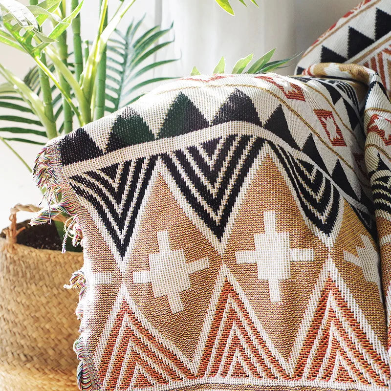 Vue détaillée du plaid bohème aux motifs ethniques, motifs aztèques en terracotta, noir et beige.