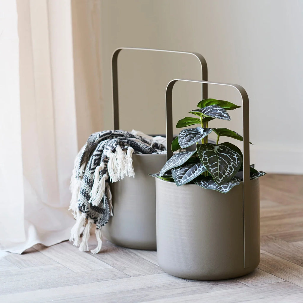 Jardinières cylindriques taupe modernes avec poignées métal, plantes vertes, tissu à carreaux beige-noir frangé
