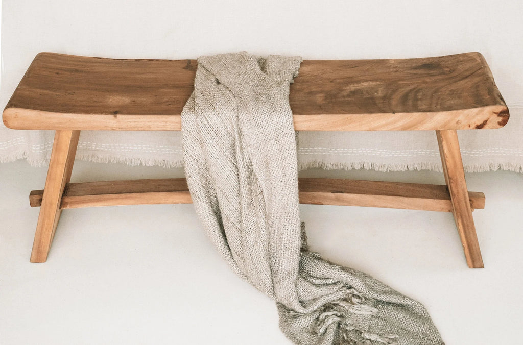 Banquette en bois courbée avec plaid beige à franges pour lit ou canapé
