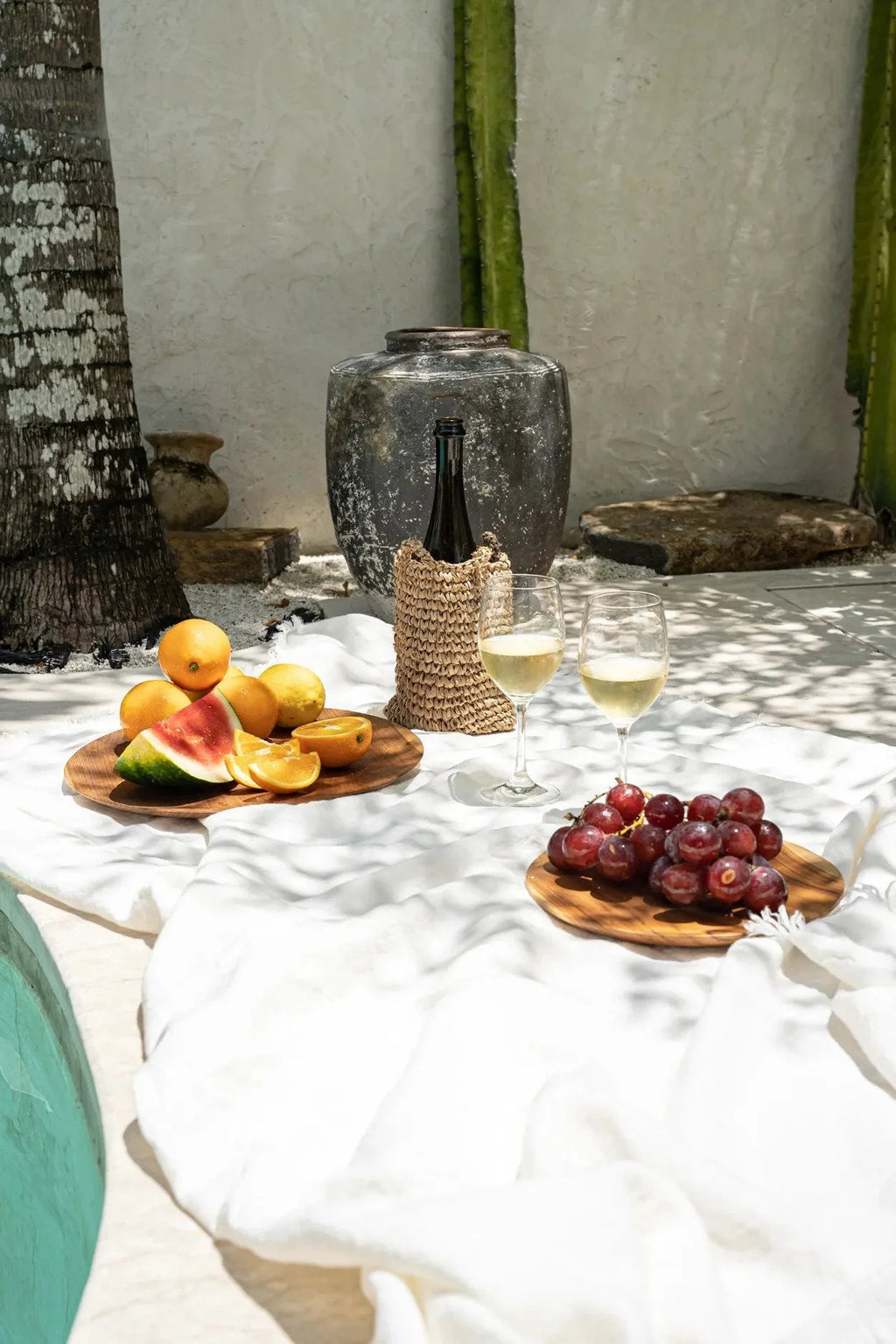 Plateau rond en racine de teck avec pique-nique tropical, vin, fruits et raisins