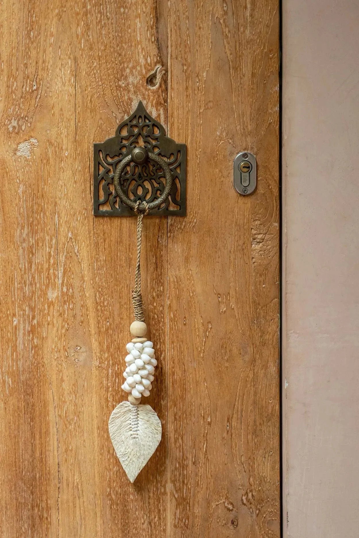 Poignée de porte en métal ornée d’une feuille décorative et d’une perle à pompon