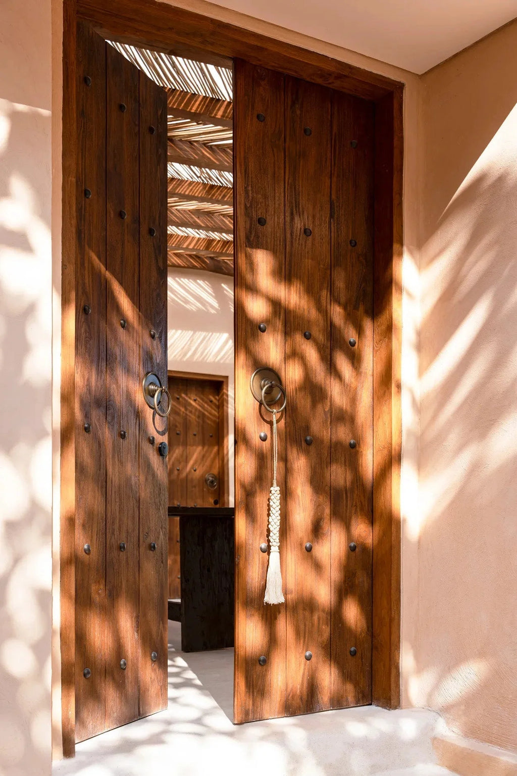 Porte double en bois avec pompon et quincaillerie laiton