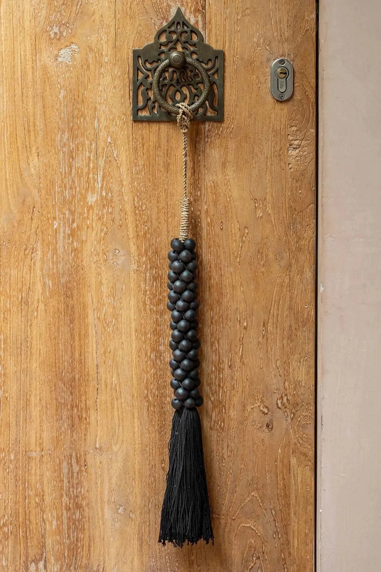 Tassel décoratif en perles de bois noir avec anneau en métal orné, suspendu