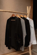 Blouse en soie noire légère sur portant à vêtements en teck naturel 120x50 cm