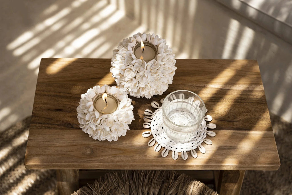 Porte-bougie floral blanc en coquillages sur table bois rustique