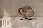 Objet décoratif rond en fibres naturelles et coquillages sur socle noir