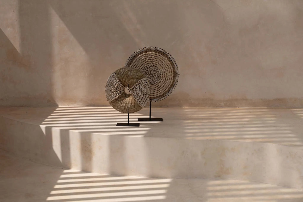 Deux disques décoratifs en fibres naturelles et coquillages sur socle noir