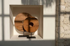 Sculpture décorative en teck naturel rond avec trou central sur socle noir H50 cm