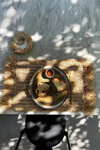 Set de table en raphia naturel à franges avec sandwich sur une assiette rustique