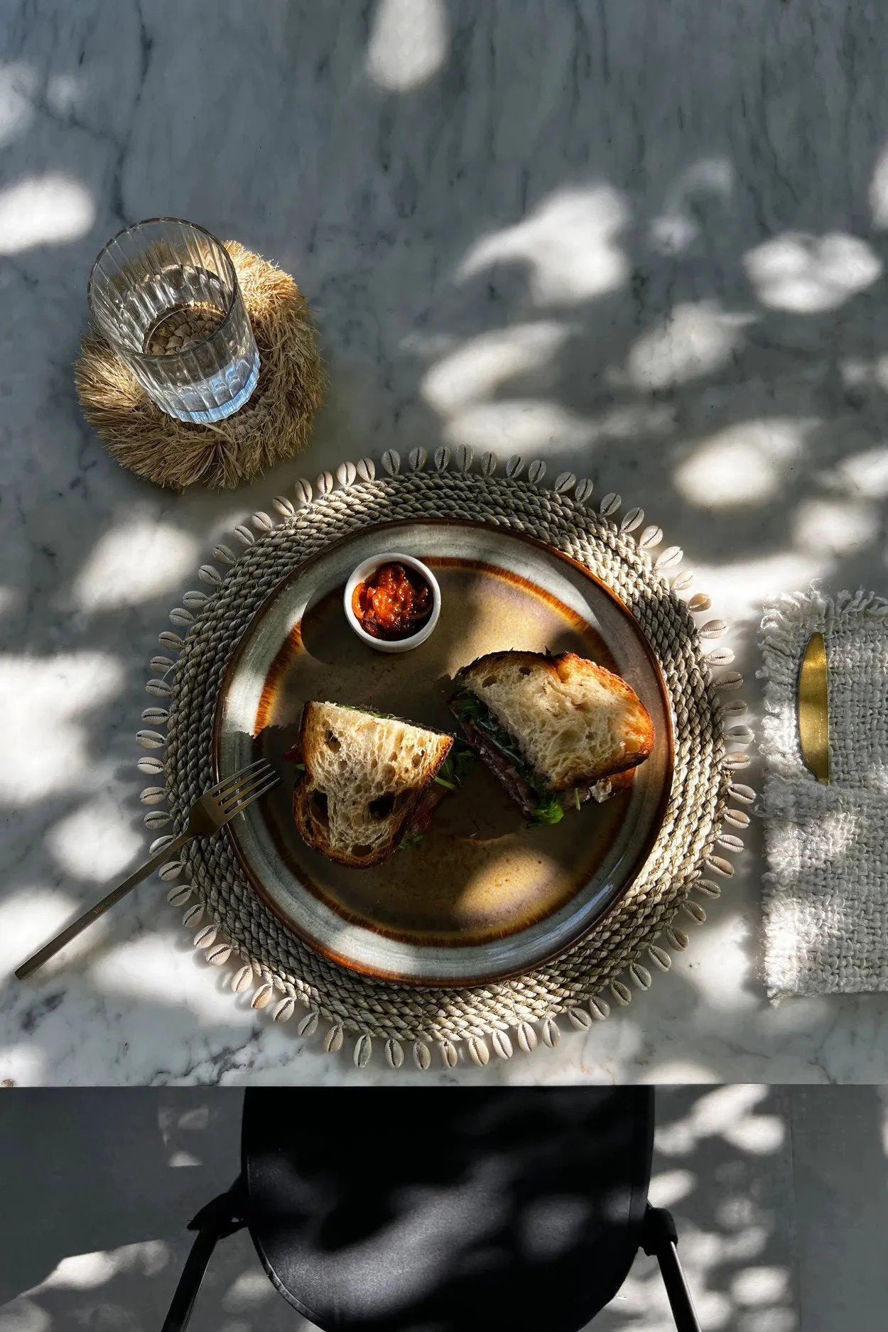 Deux moitiés de sandwich sur une assiette en jonc de mer avec relish rouge naturelle