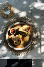 Sandwich rustique avec relish sur un set de table rond en jonc de mer avec coquillages naturels