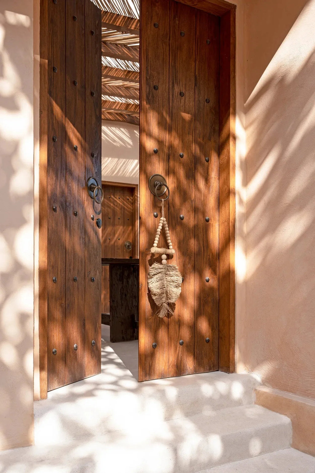 Paire de portes en bois rustique ornées de clous métalliques et pendentif en feuille