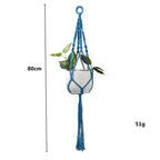 Suspension en macramé bleu rond avec franges décoratives et plante verte à l’intérieur