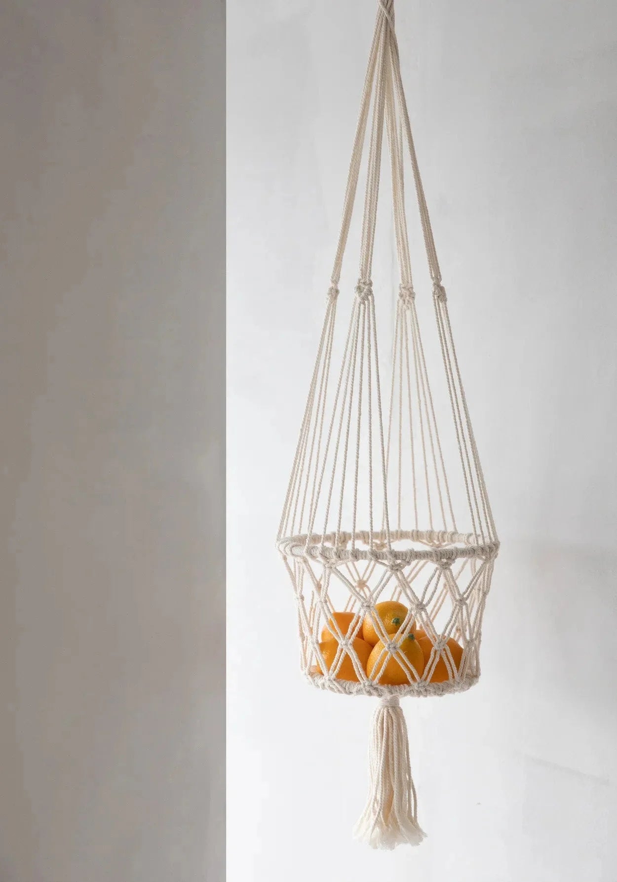 Suspension plante macramé en coton blanc cassé avec franges tenant plusieurs oranges