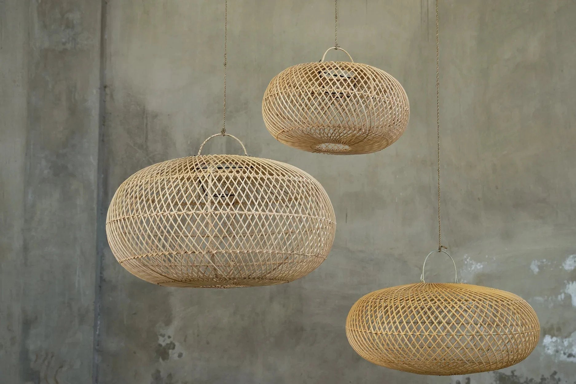 Trois suspensions en rotin naturel tressé ovale, 60 cm, motif diamant, mur béton