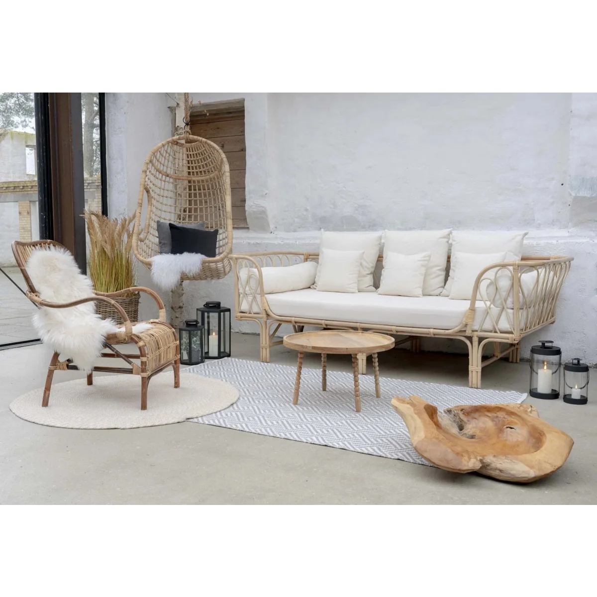 Banc de jour en rotin clair avec coussins blancs, parfait pour la décoration intérieure
