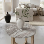 Vase céramique blanc texturé à anse avec branches dolivier sur table ronde marbre blanc pied bois clair Ø50 cm