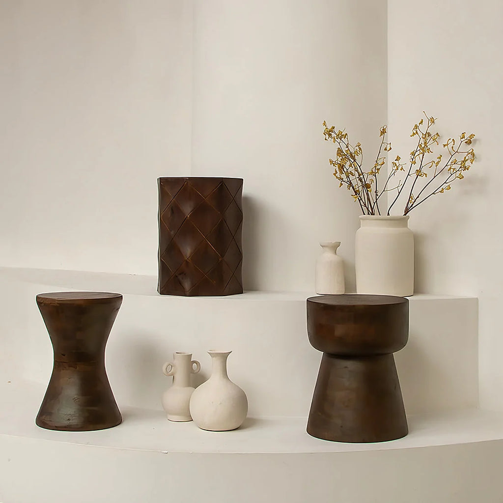Tabouret artisanal en bois brun foncé, silhouette sablier effilée